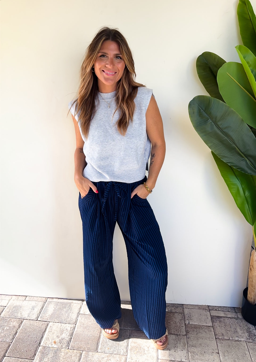 After Hours Stripe Pants styled with a light blue sleeveless knit top and wedge sandals.