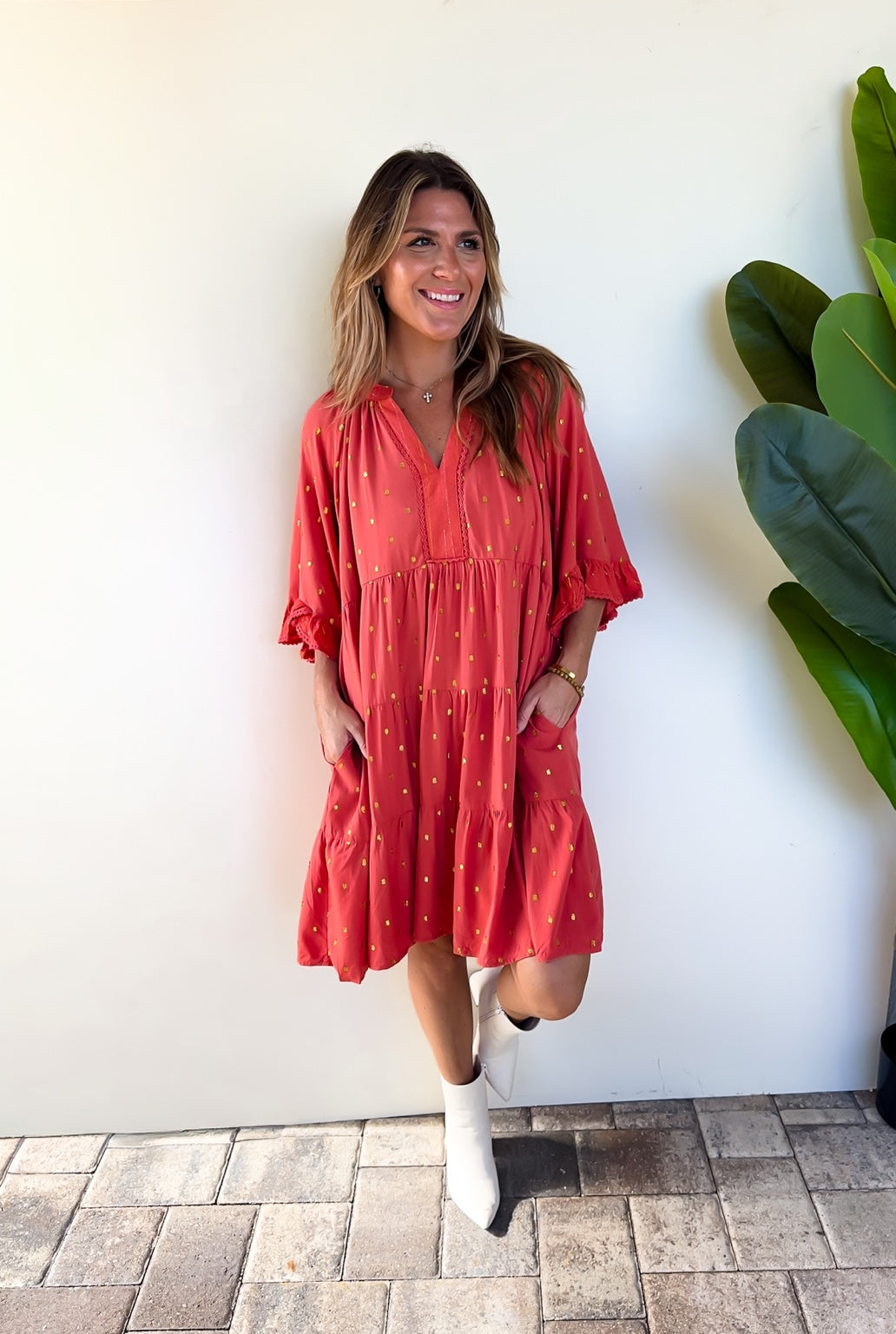 Full-length view of the Copper Confetti Dress with hands in its side pockets.