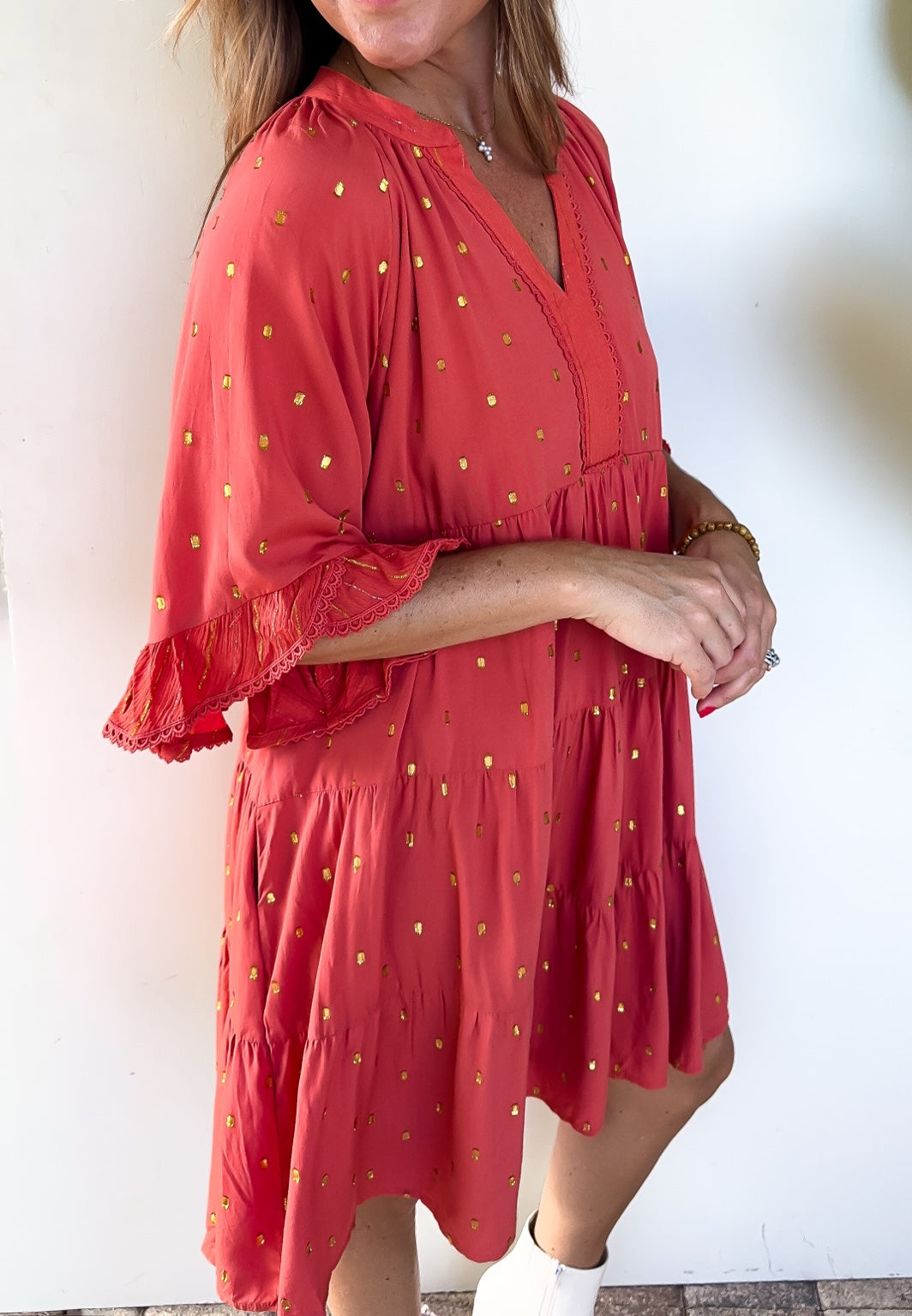 Side detail of the Copper Confetti Dress showing layered ruffle cuffs and delicate trim.