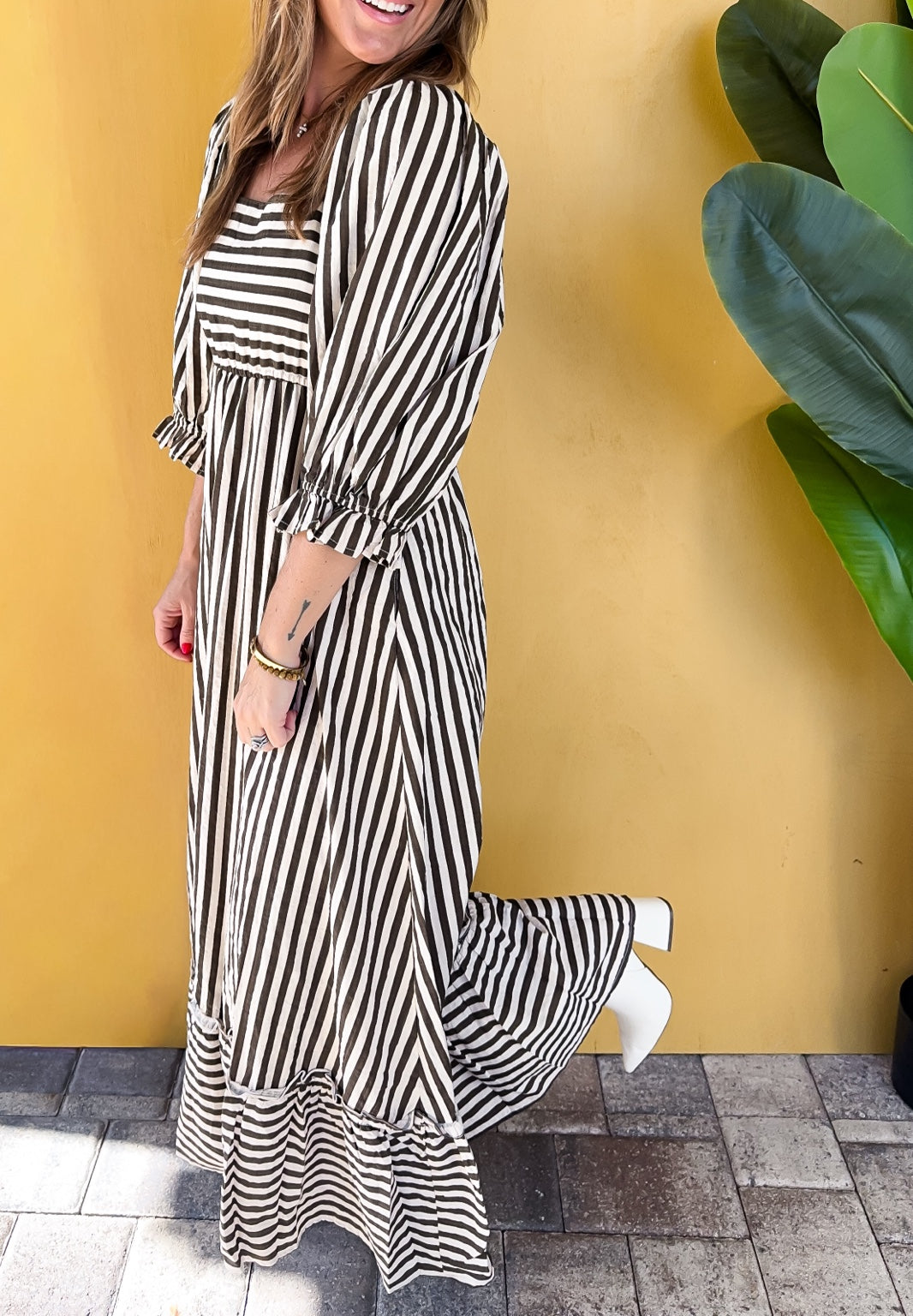Side view of the Sweet on Fall Maxi Dress showing puff sleeves and the striped ruffle hem.