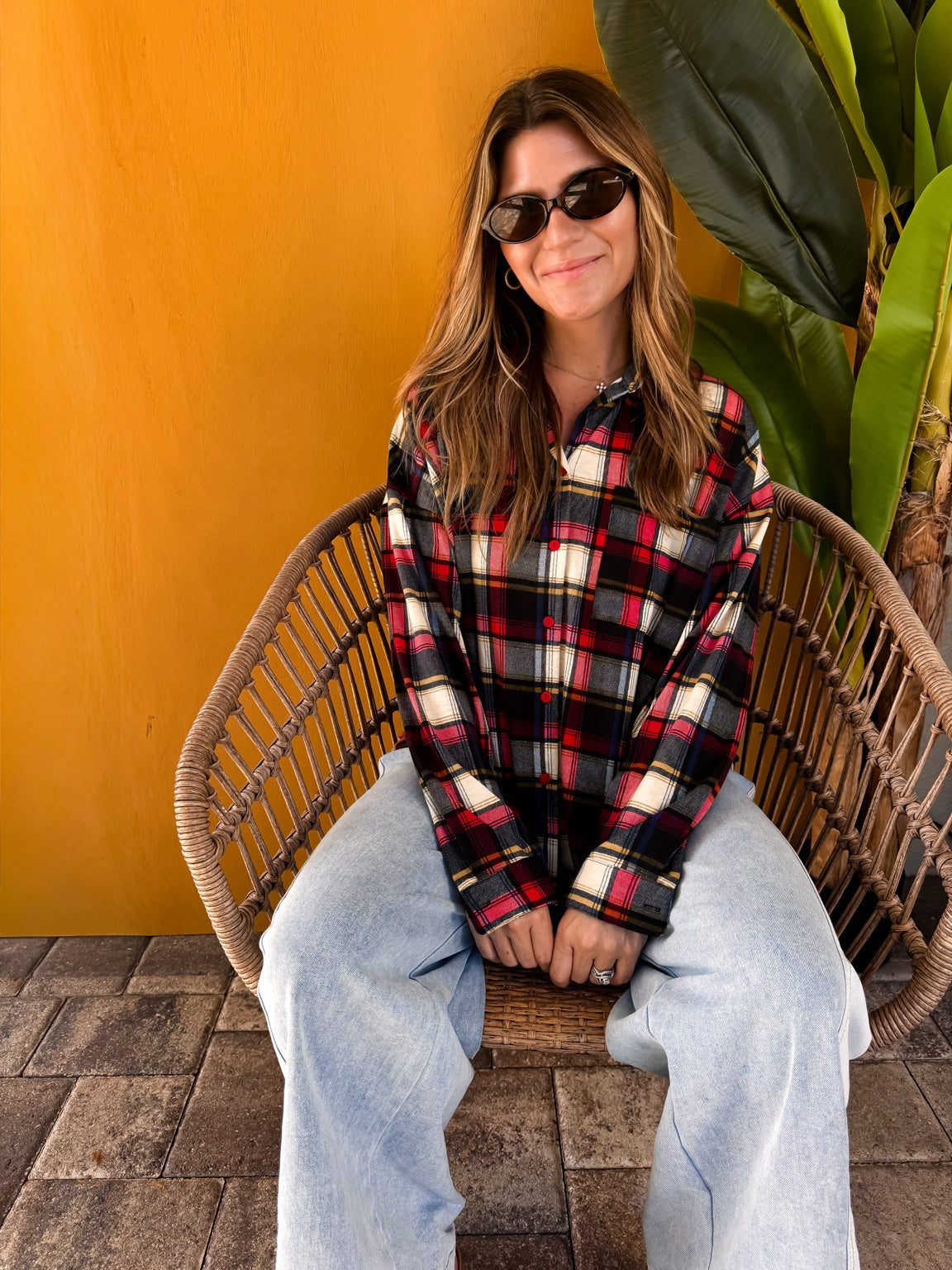 Model seated wearing the Plaid to Meet You Shirt with light-wash jeans.